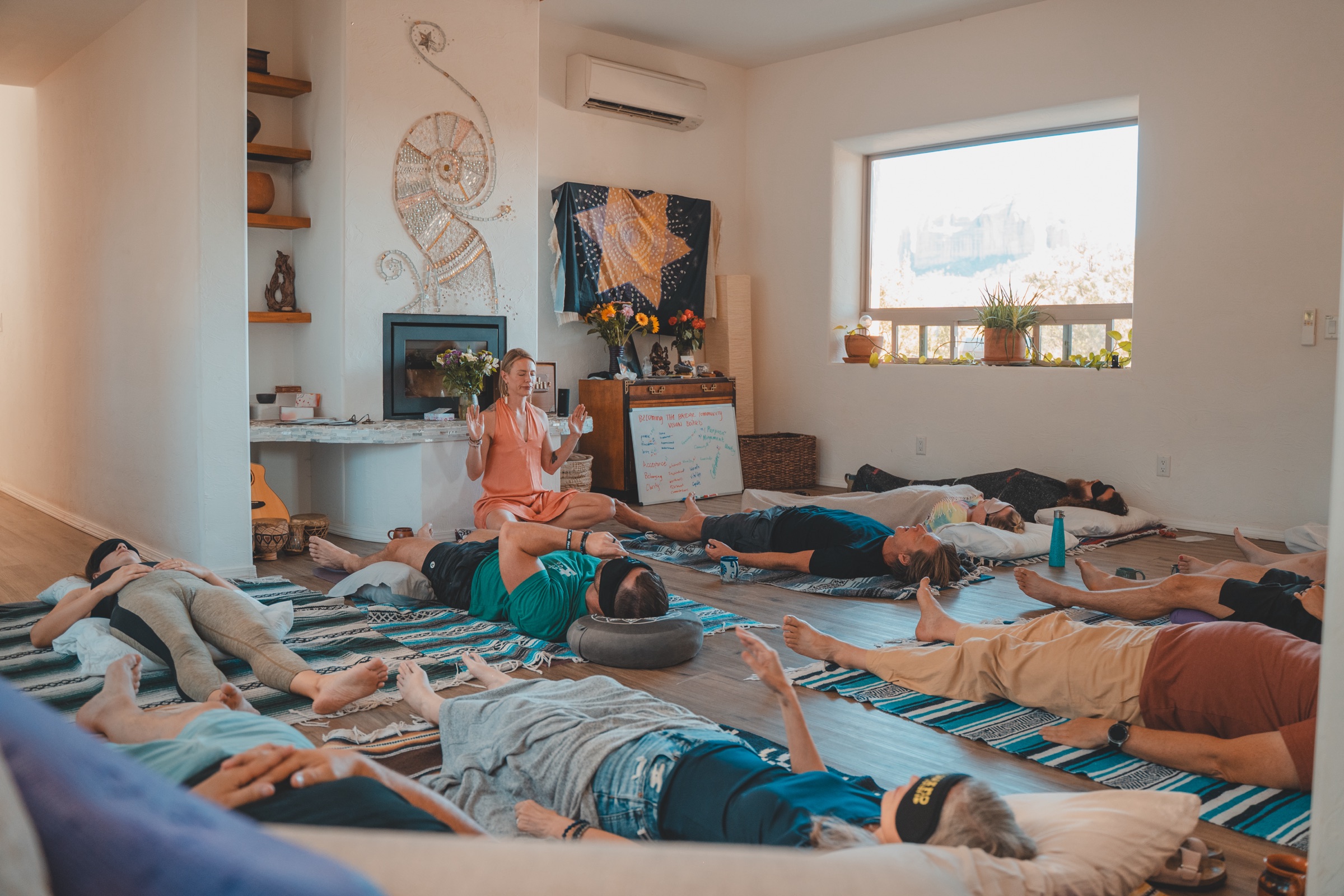 Chelsea leading a breathwork session on the floor of a light-filled Sedona room