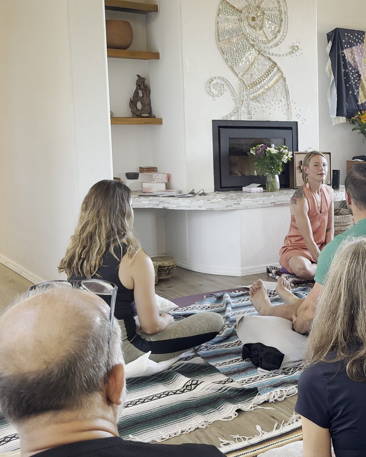 A facilitated circle session, participants seated on the floor in morning light