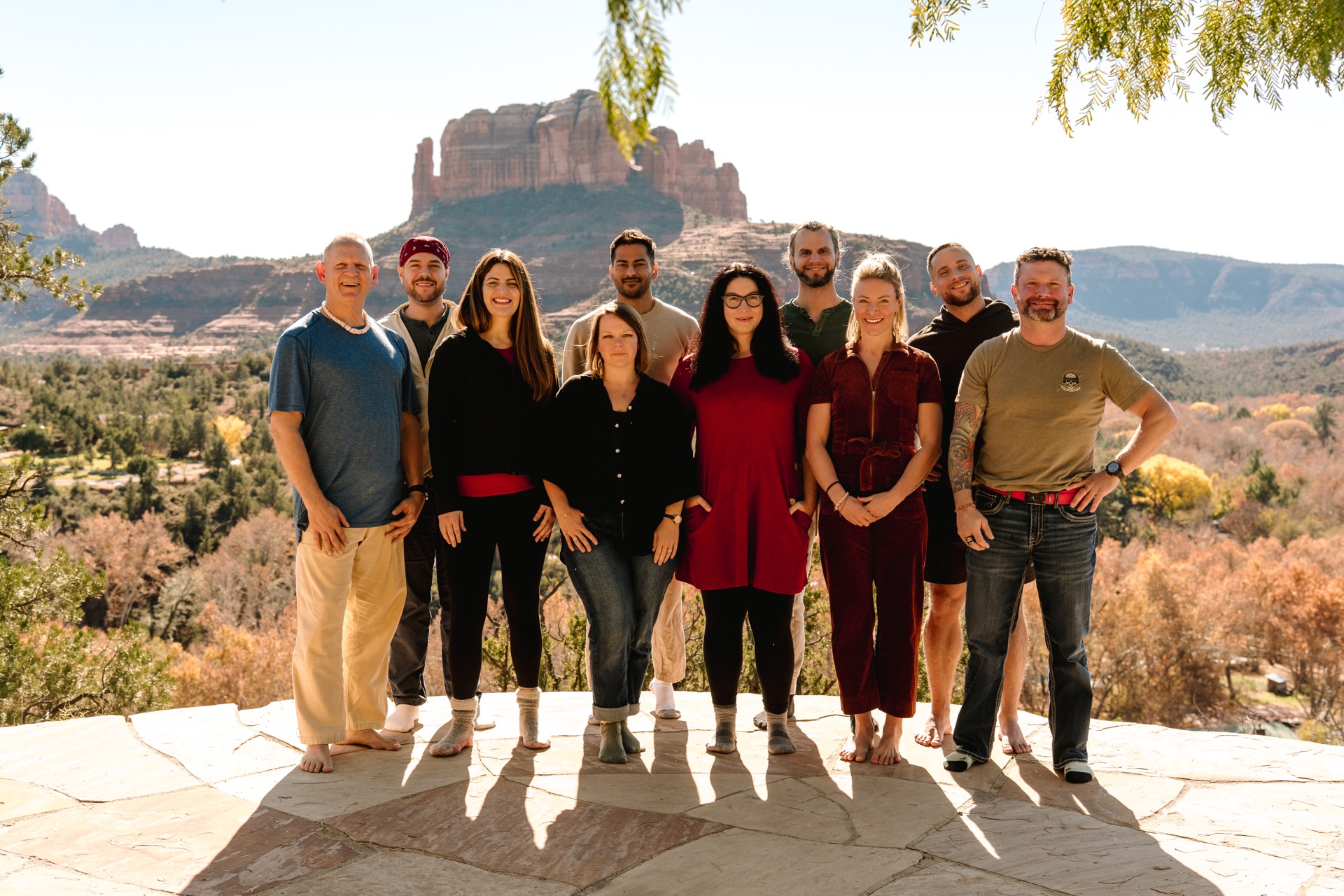 The December cohort on a stone terrace, Cathedral Rock behind them, Sedona
