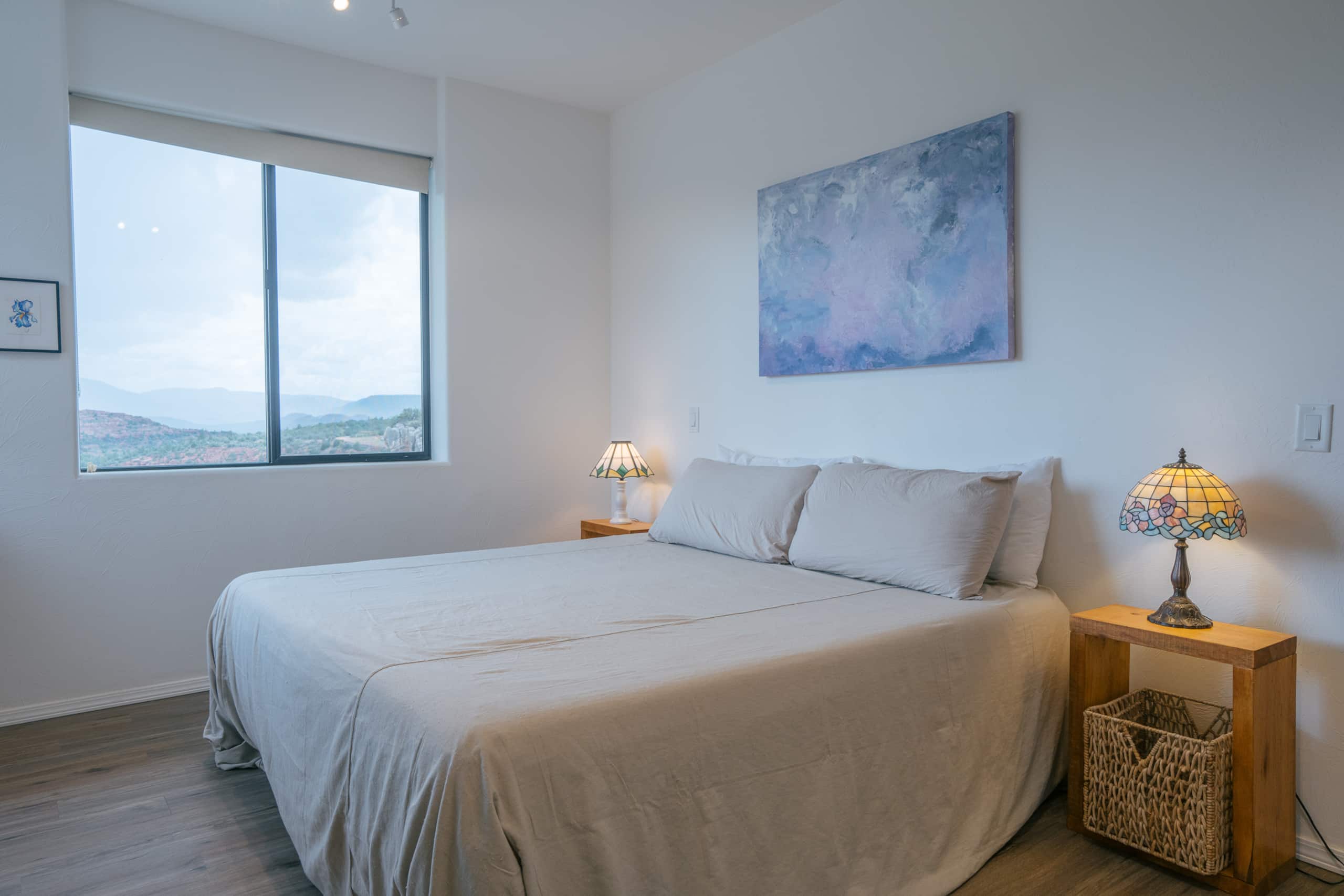 Private bedroom with a king bed, window, and framed art
