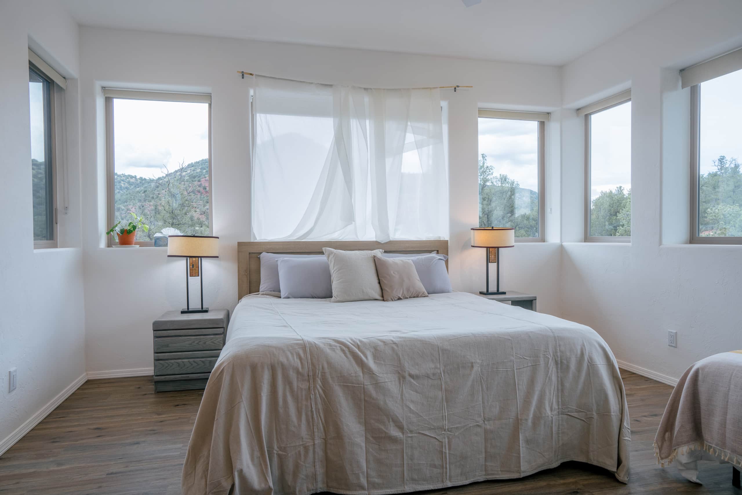 King bed in a light-filled shared room with corner windows
