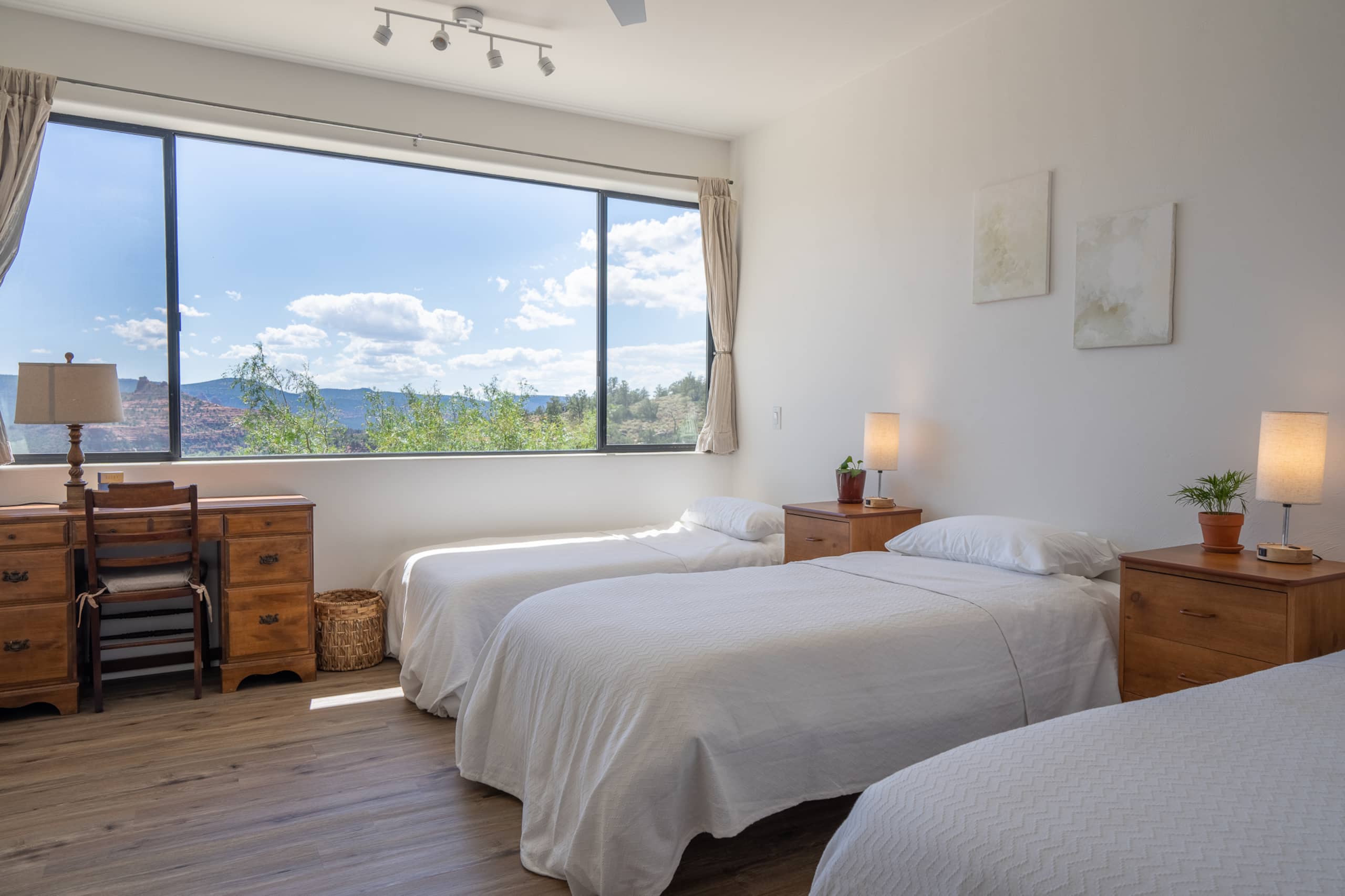 Shared room with single beds beside a window looking out to the red rocks
